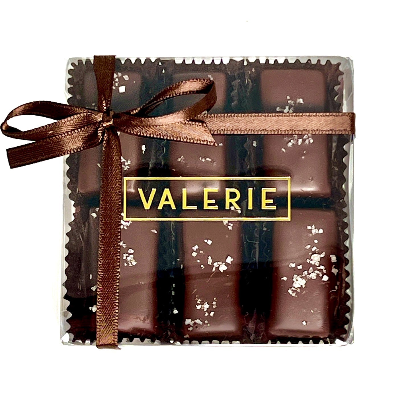 A box of Fleur de Sel Caramels from Valerie Confections, featuring chocolate-covered almond-studded caramels sprinkled with delicate sea salt and tied with an elegant brown satin ribbon.