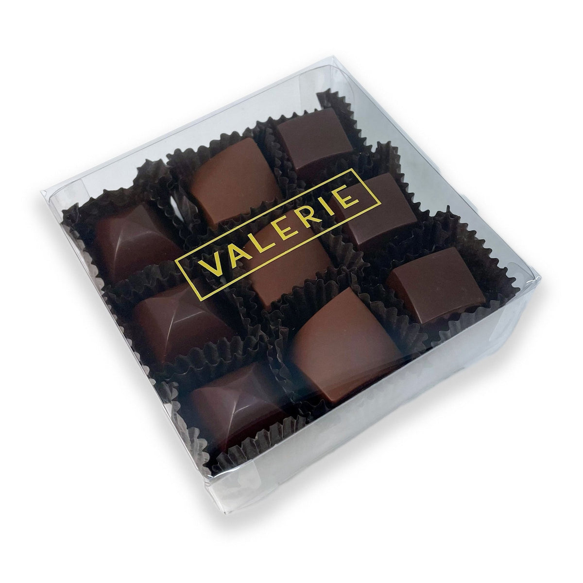 A luxurious box of Valerie Confections&#39; Happy Hour Truffles, featuring spirit-infused chocolates elegantly packaged in a clear box with a gold Valerie logo.