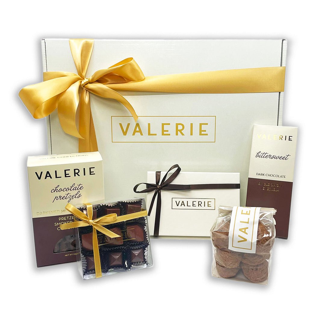 Collection of "VALERIE" branded chocolates and confectionery with a large white gift box tied with a golden ribbon.
