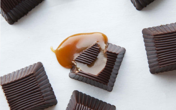 Chocolate candies with caramel center on a white surface
