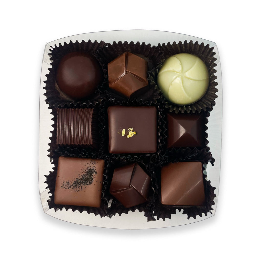 Open Small Truffle Assortment box showcasing gourmet chocolates in a clear container.
