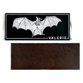 A 72% bittersweet chocolate bar with black lava salt, unwrapped and displayed with its bat-themed packaging.