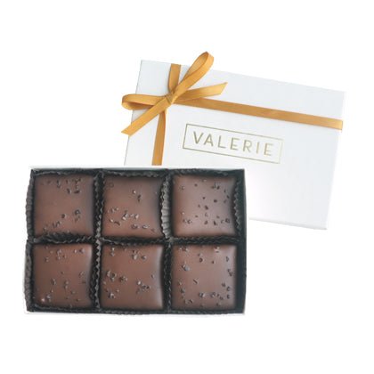A box of Durango Toffee, featuring six pieces of darkened milk chocolate-coated almond toffee sprinkled with smoked salt.