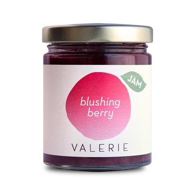 A jar of "blushing berry" jam labeled "VALERIE" with a gold lid.