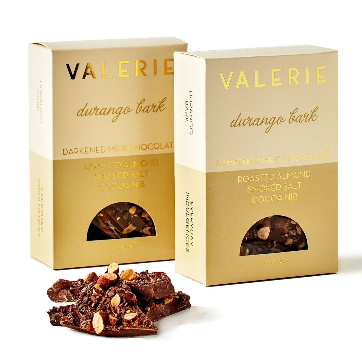 Two boxes of Valerie Durango Bark chocolate and several pieces of the bark with visible toppings of almonds and cocoa nibs.