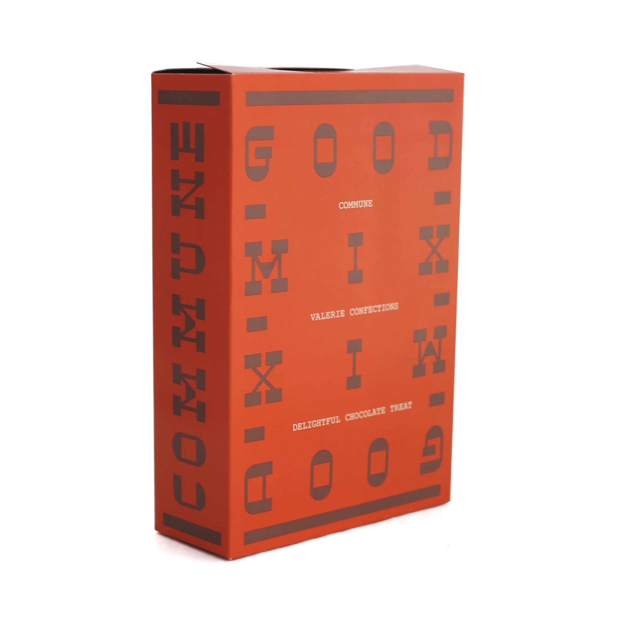 Rectangular orange box of GOOD MIX chocolate snack with dark brown blocky text design.