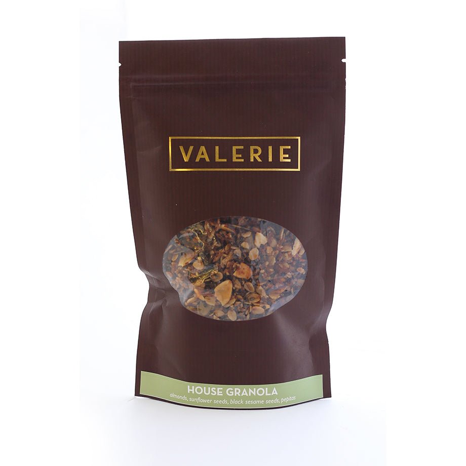 Brown stand-up pouch of Valerie House Granola with an oval window showing mixed granola.