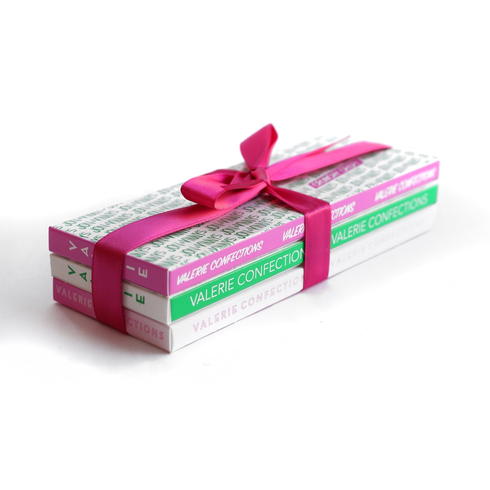 Stack of three Valerie Confections chocolate bars tied with a pink ribbon.