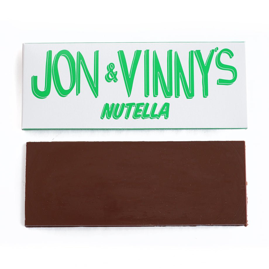 Jon &amp; Vinny&#39;s Nutella milk chocolate bar with white packaging displaying green text, and the unwrapped chocolate bar below.