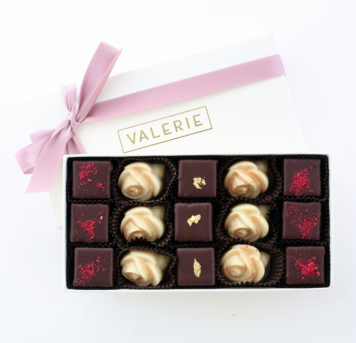 Assortment of chocolates in an ivory box with a violet satin ribbon and &quot;VALERIE&quot; written on the lid.