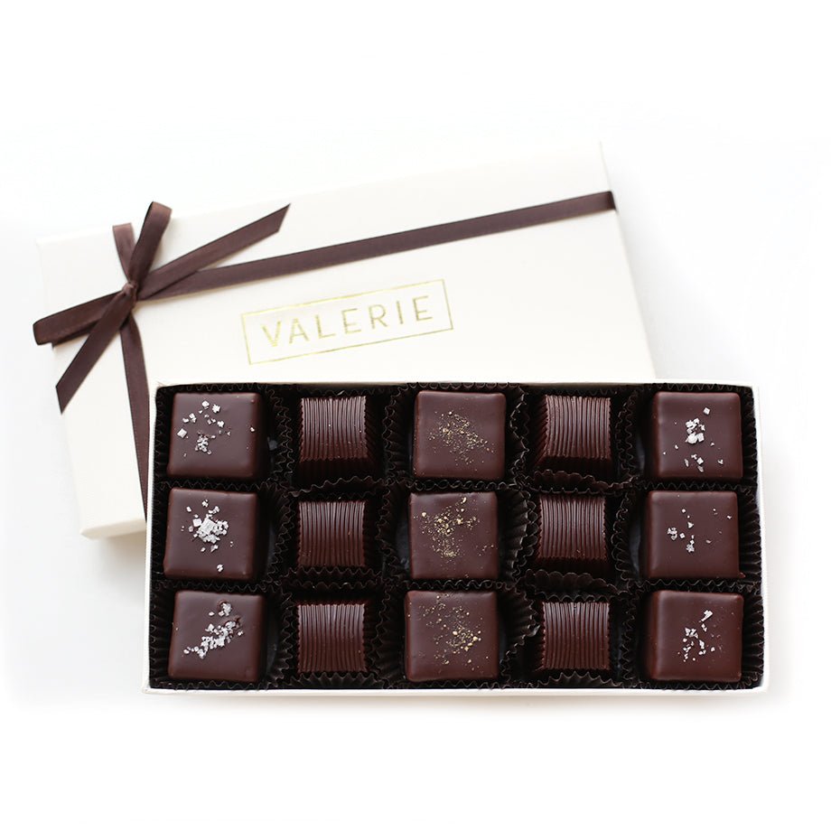 Box of twelve dark chocolates with some topped with fleur de sel or pepper, in an ivory box with "VALERIE" label and brown ribbon.