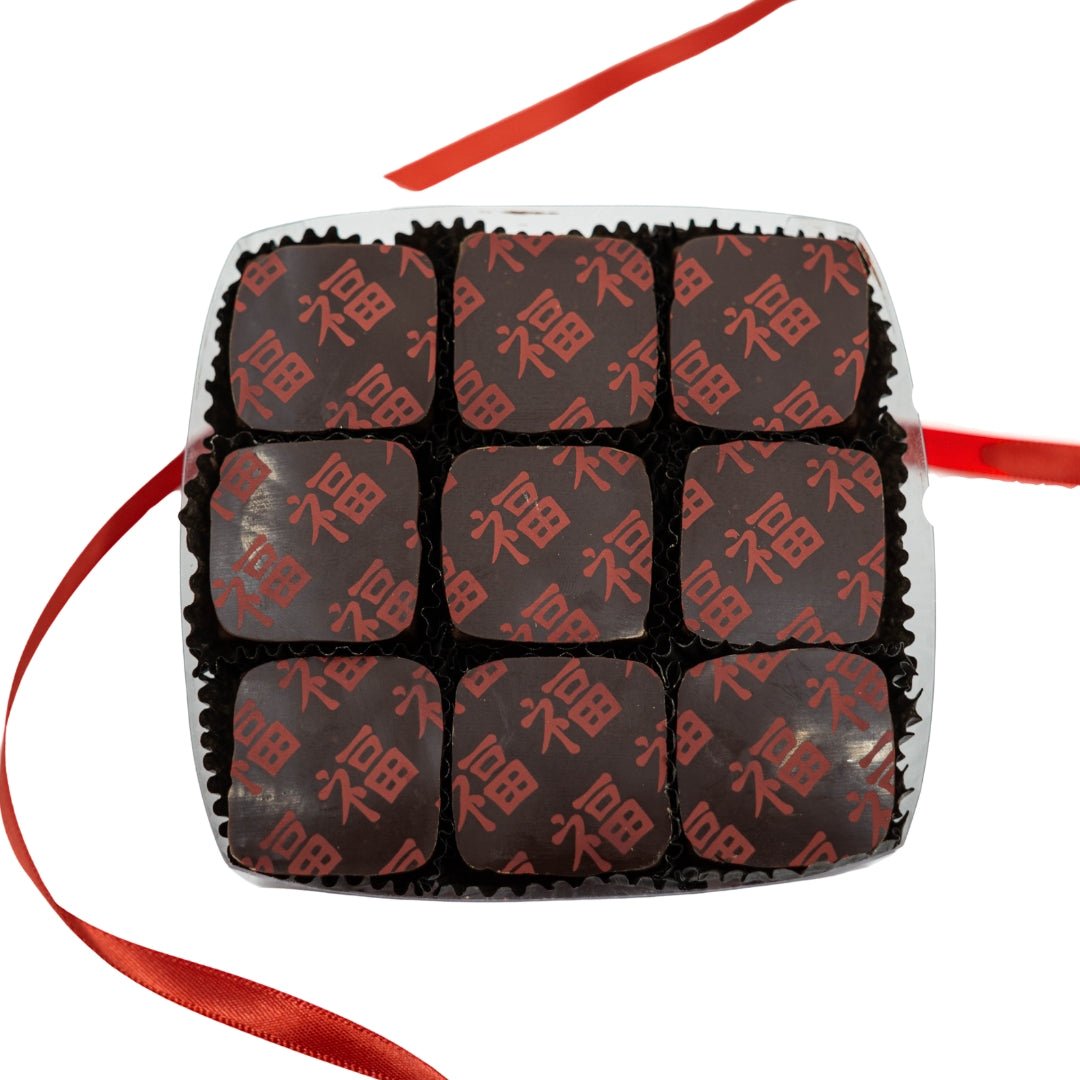 Box of nine square chocolates with red Chinese characters, presented with a red ribbon.