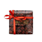 Box of nine square chocolates with red Chinese characters, presented with a red ribbon.