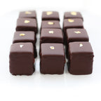 Close-up of luxury Champagne Petits Fours, highlighting the dark chocolate coating and gold leaf decoration.
