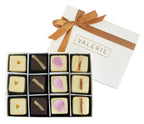 A luxury 12-piece Assorted Petits Fours gift box from Valerie Confections, tied with a satin ribbon, showcasing four signature flavors.
