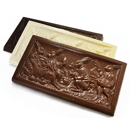 Three embossed rectangular chocolate bars in milk, white, and dark chocolate, each featuring rabbits in various Easter activities.