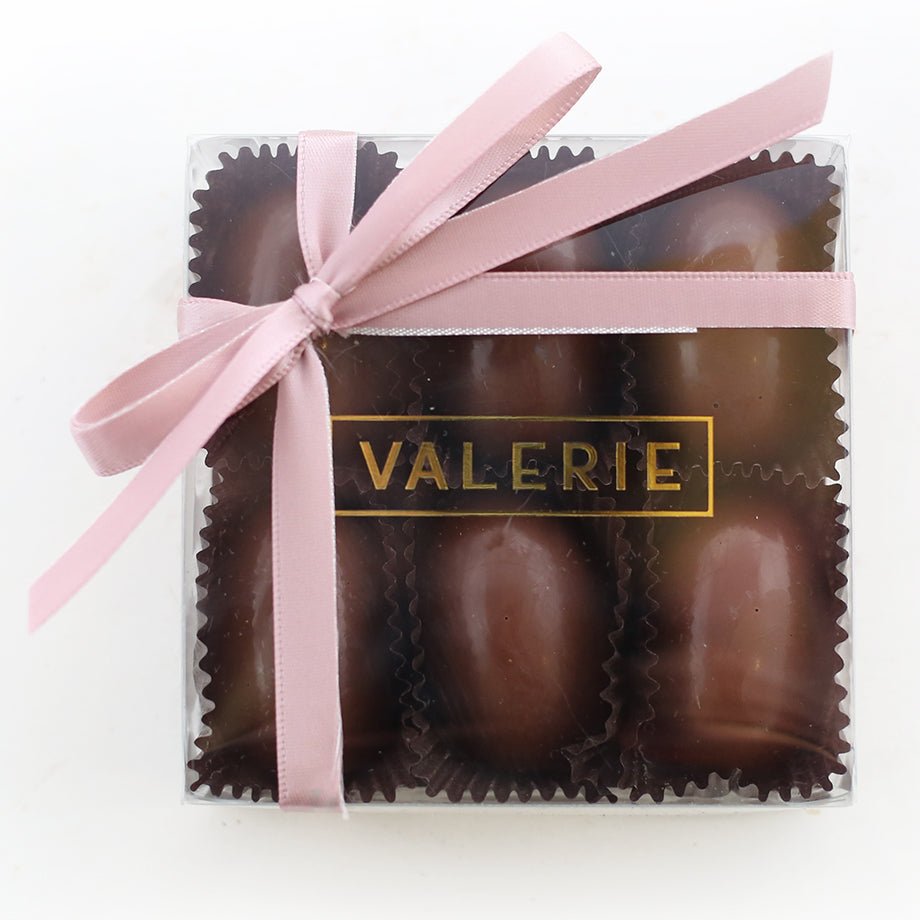 Clear box of six milk chocolate ganache eggs with a pink ribbon and &quot;VALERIE&quot; label.