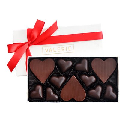 Box of heart-shaped chocolates with a red ribbon and the word "VALERIE" on the lid.