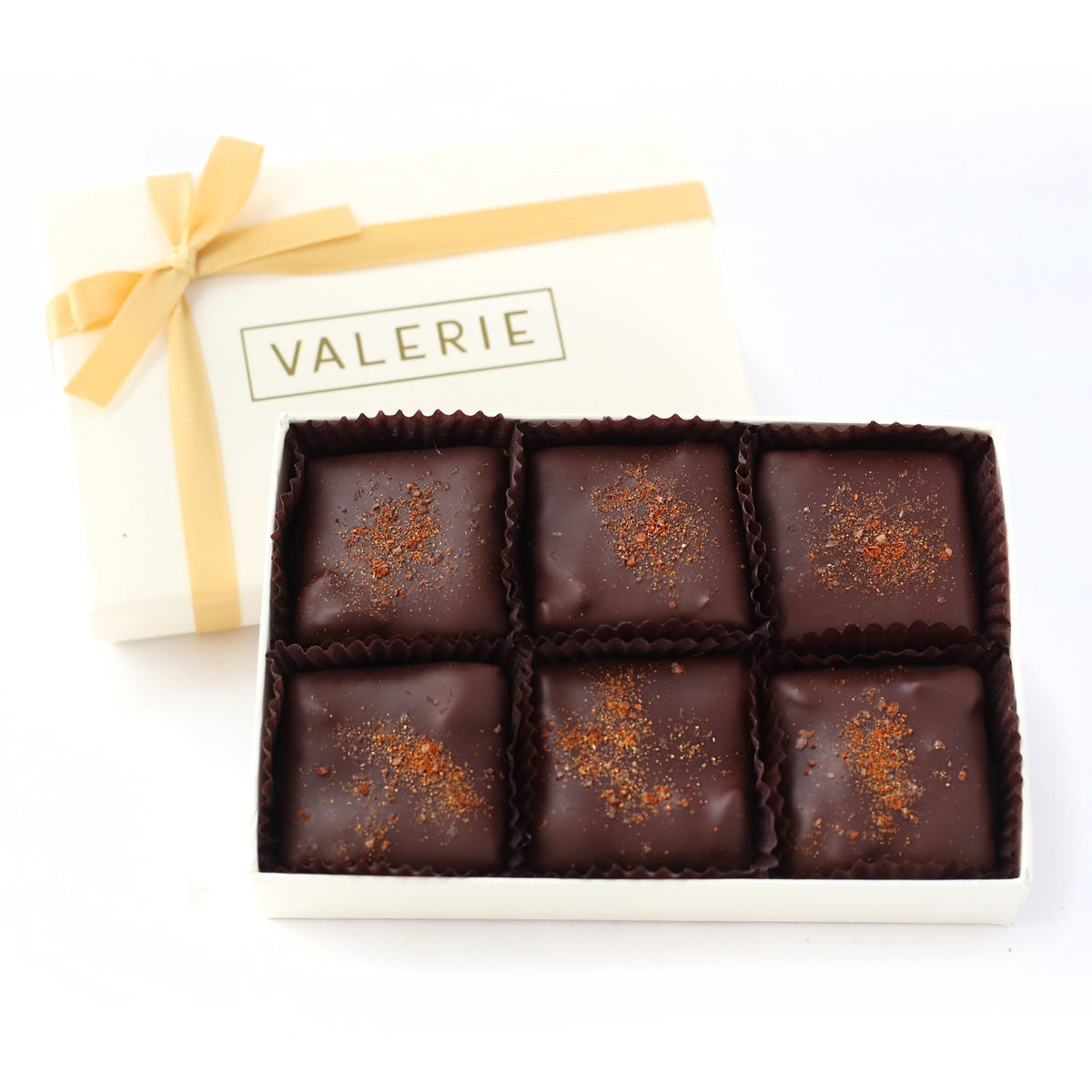 Box of six dark chocolate-covered toffees with paprika and salt sprinkles.