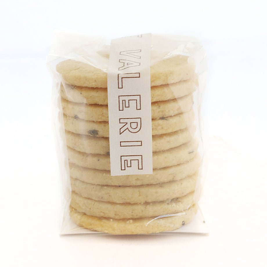  A stack of light golden-brown cookies in a transparent plastic package with a white label that reads &quot;VALERIE.&quot;