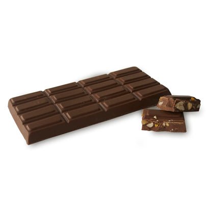 A large segmented chocolate bar with two smaller pieces broken off, showing nuts and dried fruits inside.