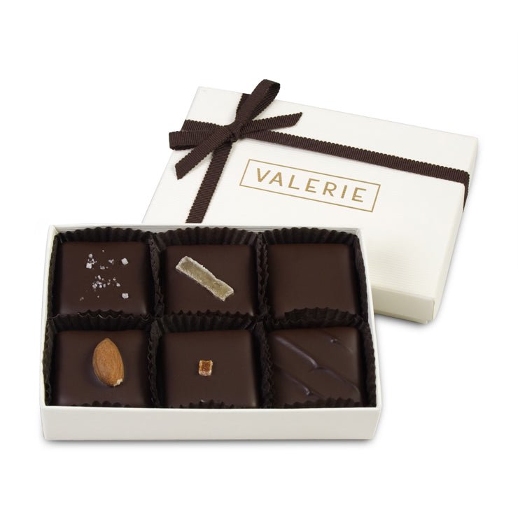 A box of six handmade toffee chocolates, each with a different topping, labeled &quot;VALERIE.&quot;