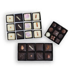 Assortments of petits fours, truffles, and toffee in three rectangular boxes.