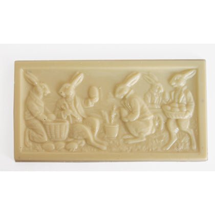 Rectangular white chocolate bar with raised Easter design of four rabbits engaged in various activities.